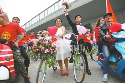 小伙骑共享单车迎娶新娘 50辆迎亲车队成街头一景