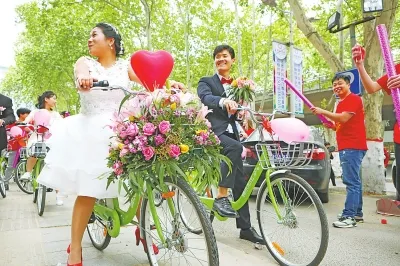 小伙骑共享单车迎娶新娘 50辆迎亲车队成街头一景